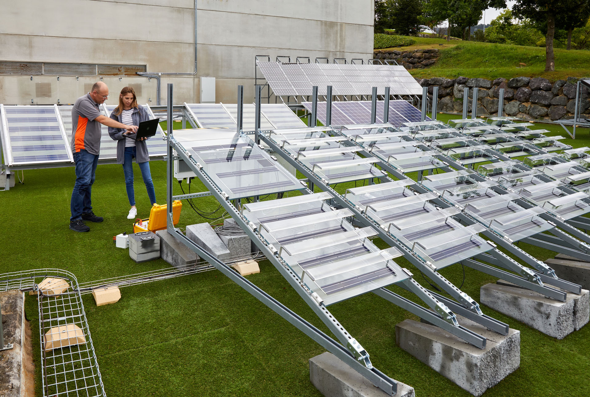 Investigadores con ordenador junto a paneles fotovoltaicos