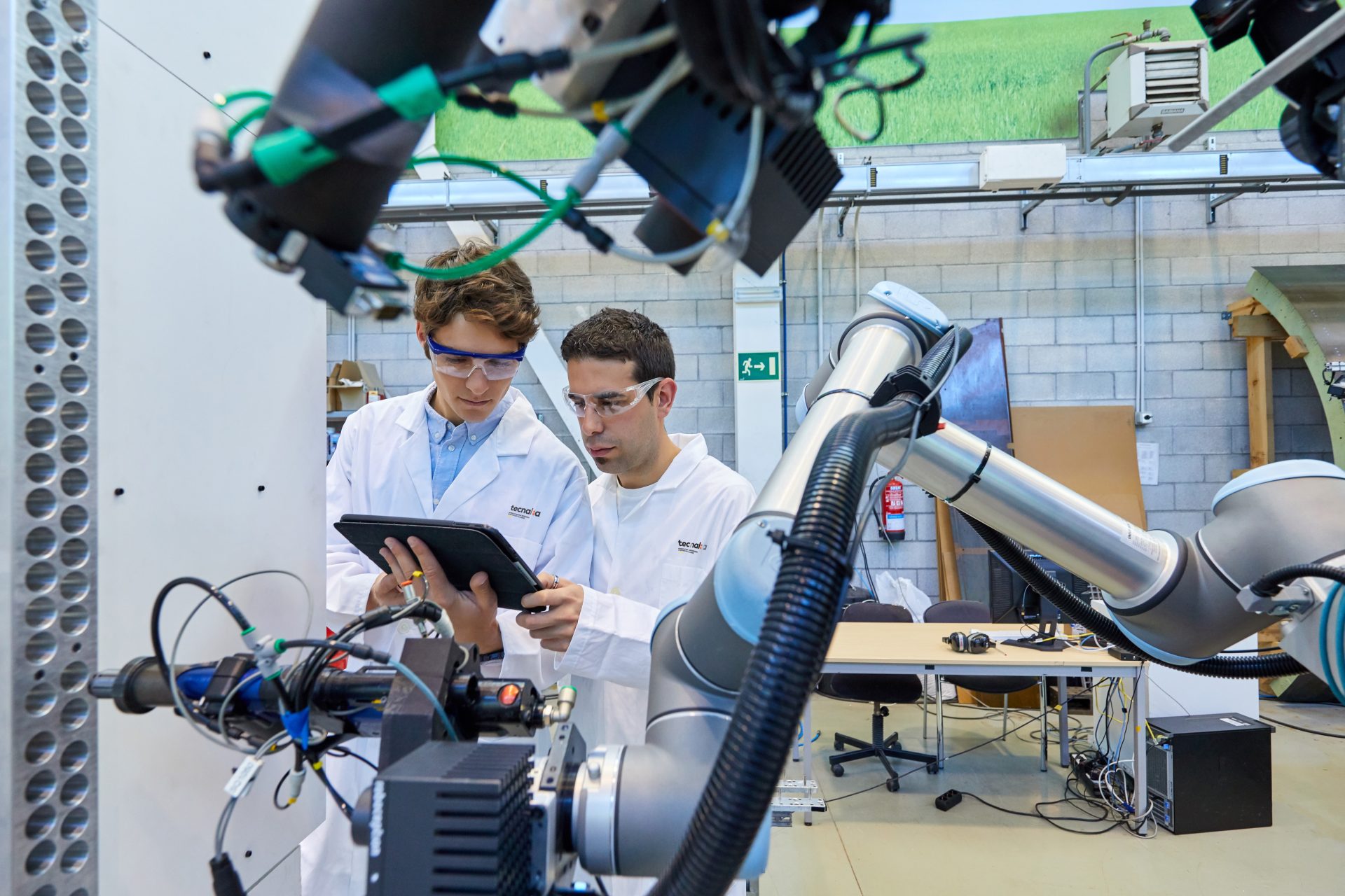imagen de dos investigadores de TECNALIA con un brazo robótico representando los proyectos de I+d+i